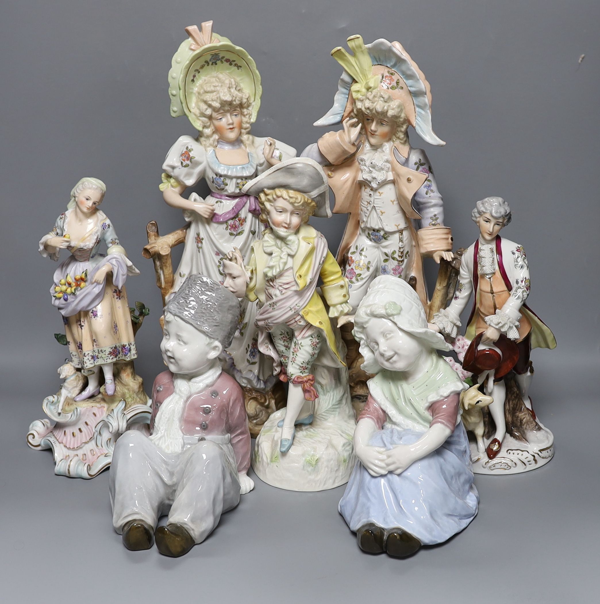 A collection of German and French porcelain figurines, tallest 39.5cm high